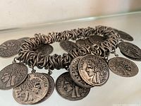 Full view of bracelet showing link construction and attached French coin charms