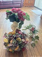 Overall view of three artificial arrangements on wood floor