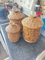 Front view of all three canisters showing size differences and embossed design