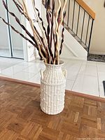 Full view of white bamboo-textured floor vase with branches