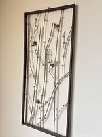 Full view of rectangular metal wall art with branches and birds