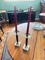 Full view of both candlesticks with taper candles on tabletop