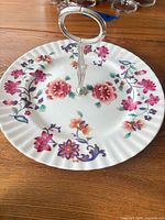 Top view of floral porcelain cake stand showing handle, pattern and rim detail