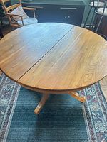 Top view of round solid wood dining table, approx 44 in. diameter