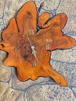 Front view of live-edge resin wall clock showing amber finish and Roman numerals