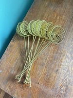 all ten gold-tone wire strainers fanned out on table