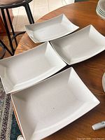 Four white rectangular ceramic platters on table