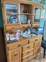 Front view of solid wood hutch showing upper glass doors, central open shelf, lower drawers and cabinet doors