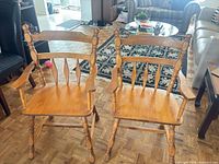 Two matching solid wood spindle-back armchairs full view