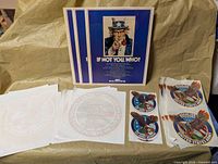 Overview: three recruiting posters, stacks of iron-on transfers, multiple eagle stickers