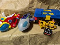 Three toys and toolbox arranged on surface