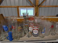 Front view showing the majority of the assorted branded beer glasses on shelf