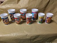 Eight Flintstones McDonald's plastic cups lined up