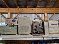 Four projectors on shelf showing overall lot