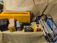 Overall view of Kodak editing outfit box, Velbon tripod, box camera, grey cine camera, Apex box, Kodak film box, cables and flash dish