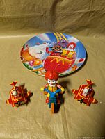 Group view of Ronald McDonald tricycle toy, two airplane toys and McDonaldland plate
