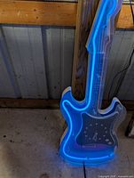 Full view of neon guitar clock lit, showing blue neon outline