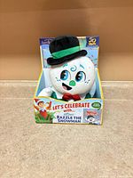 Front view of boxed Razzle the Snowman plush and book set