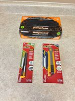 Group shot: gloves box with two OLFA utility knives in packaging