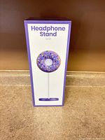Front of boxed purple donut headphone stand
