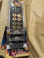 Full view of sealed Tail Devil skateboard kit showing deck, wheels, trucks