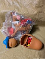 Bullseye horse figure in plastic bag and Mr. Potato Head body parts displayed
