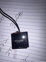 Front view of Amazon IR extender square showing logo and attached cable