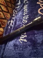Side view of full-size black flashlight on blanket