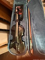 Violin inside open fitted case with accessories visible