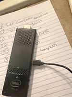 Front view of Intel Compute Stick connected to Micro-USB cable