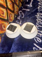 Top view of both white solar LED puck lights showing solar panels