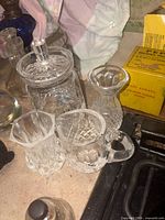 Group shot showing all three Waterford crystal pieces: lidded jar, creamer, mug