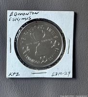 Obverse of coin in holder showing trophy and years