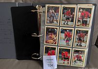 Binder open showing nine Bowman hockey cards in pages