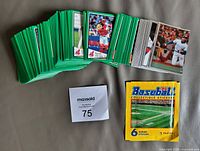 Stack of green-border stickers with some displayed fronts and sealed yellow foil pack