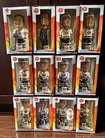 All 12 boxed bobbleheads stacked showing fronts and player names