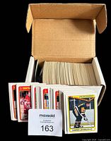 Cardboard storage box filled with stacked hockey cards, front row showing red-border Central Red Army inserts and Mario Lemieux card