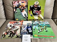 All five signed photos laid out on sofa