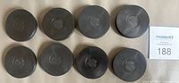 Eight black plastic pucks with NHL shield displayed top-side