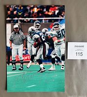 Front view of entire signed photograph showing action scene and autograph placement