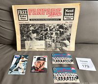 All five items laid out: newspaper, pocket schedule, signed card, two checklist cards