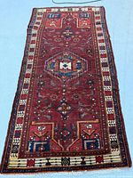 Full view of entire Zanjan Persian rug on blue background