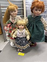 Three dolls grouped, showing relative sizes and stands