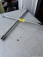 Full view of chrome 4-way lug wrench on table