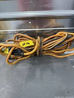 Coiled orange extension cord with plug ends visible
