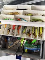 Open Fenwick tackle box showing trays filled with various lures and accessories