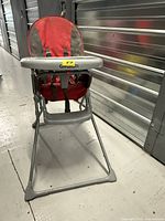 Front view of folded-out high chair showing seat, tray and frame