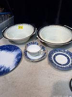 Group shot showing both serving bowls, teacup with saucer, blue transferware plate, blue splatter plate