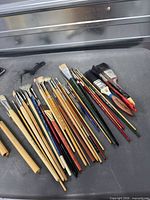 Full group of assorted artist and utility brushes on tabletop