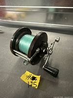 Overall view of Penn fishing reel showing frame, spool with green line, handle and drag